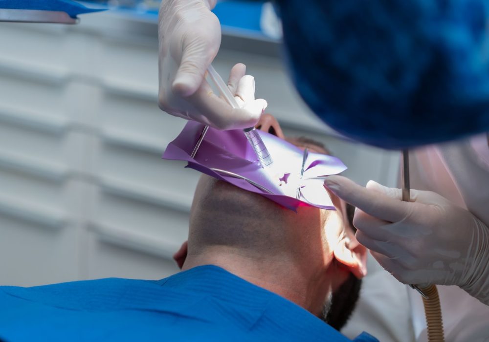 Dental clinic, detail a doctor performing an endodontics to a patient in full operation