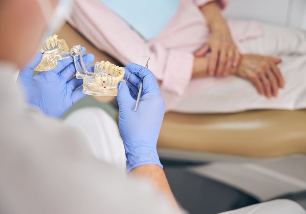 Doctor hands holding jaw model while taking consultation for patient in the orthodontist office